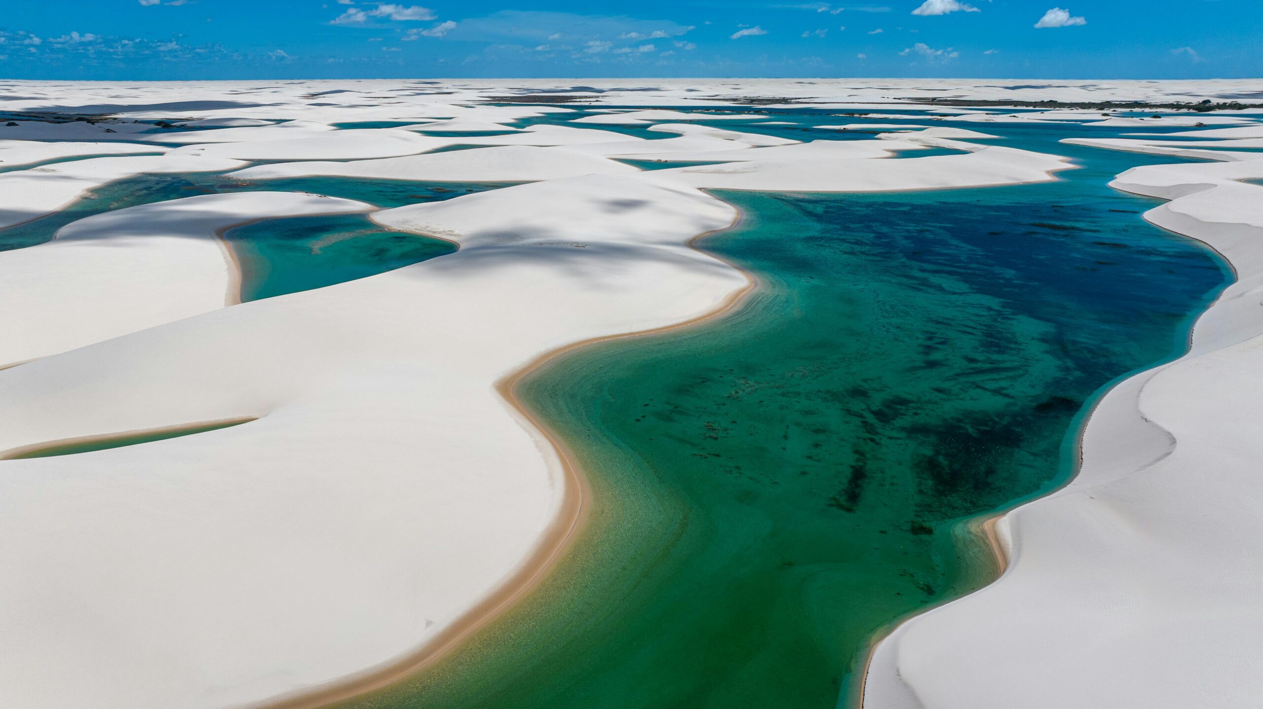 Stunning aerial view of Lençóis Maranhenses' turquoise lagoons and white sand dunes in Brazil.