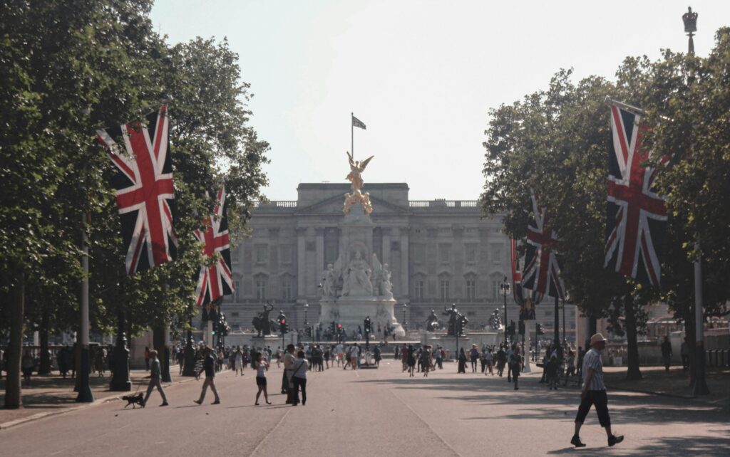 A vibrant day at Buckingham Palace with Union Jack flags and tourists exploring.